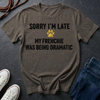 Brown Comfort Colors t-shirt with humorous text and paw print on a dark surface with shoes and jeans.