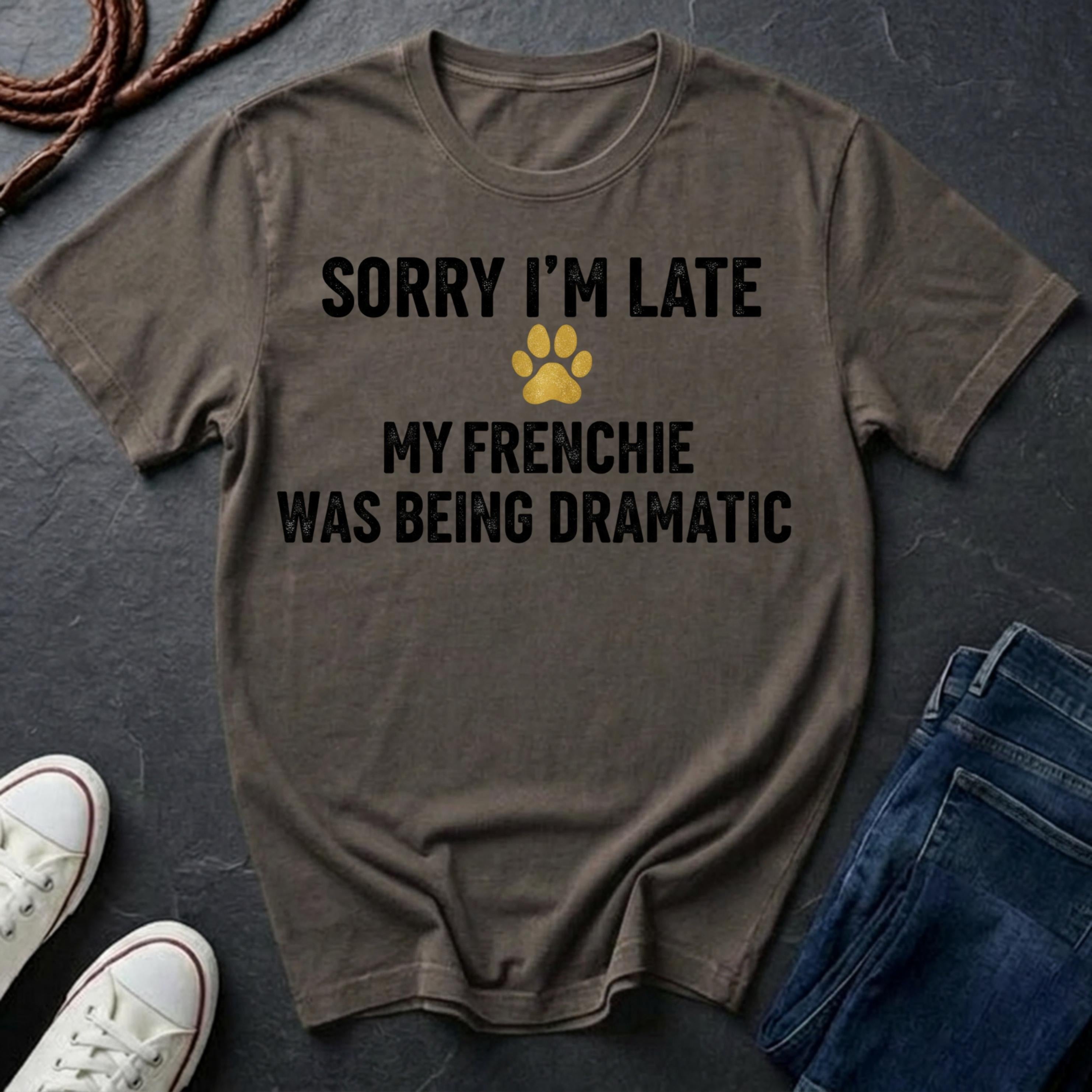 Brown Comfort Colors t-shirt with humorous text and paw print on a dark surface with shoes and jeans.