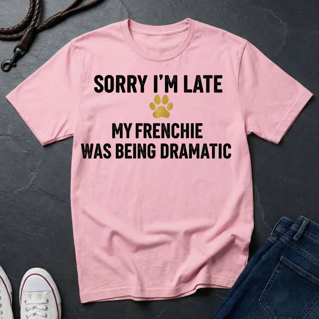 Pink Comfort Colors t-shirt with text 'Sorry I'm late, my Frenchie was being dramatic' on a dark surface.