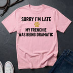 Pink Comfort Colors t-shirt with text 'Sorry I'm late, my Frenchie was being dramatic' on a dark surface.