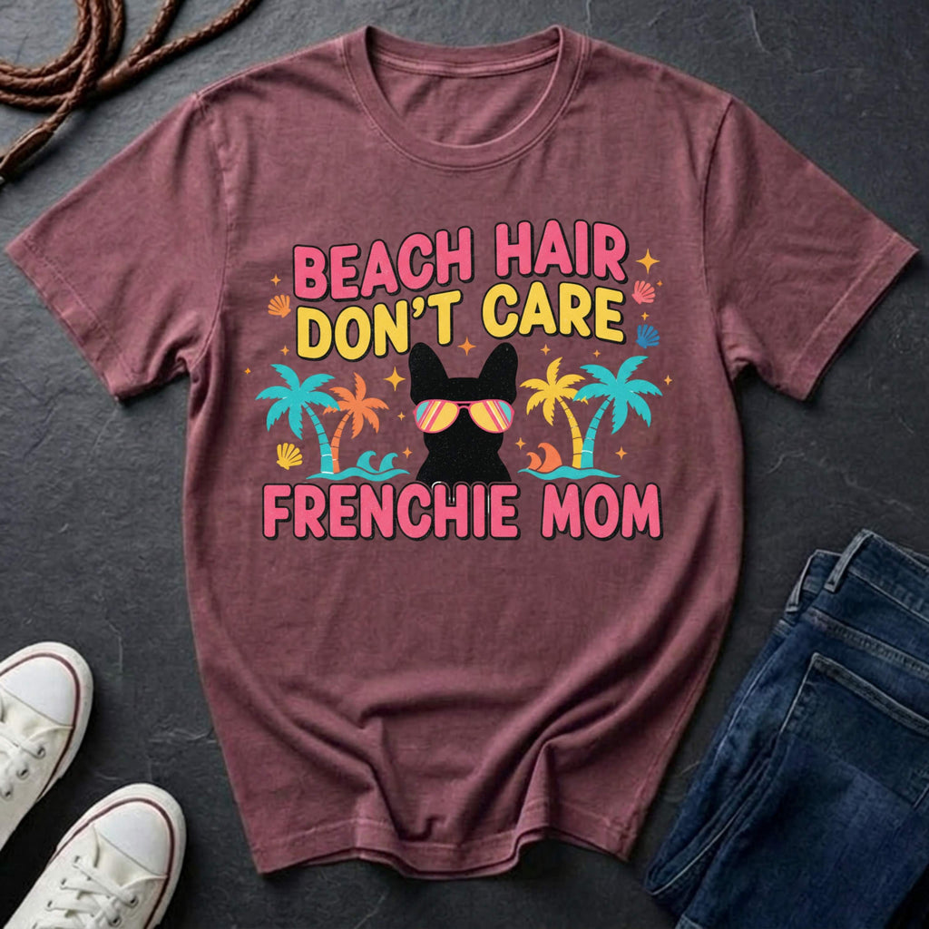 Maroon Comfort Colors t-shirt with 'Beach Hair Don't Care Frenchie Mom' design on a dark surface with shoes and jeans.