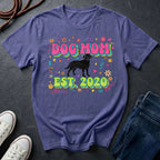 Purple Comfort Colors t-shirt with 'Dog Mom Est. 2020' design on a dark surface with shoes and jeans.