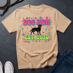 Beige Comfort Colors t-shirt with 'Dog Mom Est. 2020' design on a dark surface with jeans and shoes.