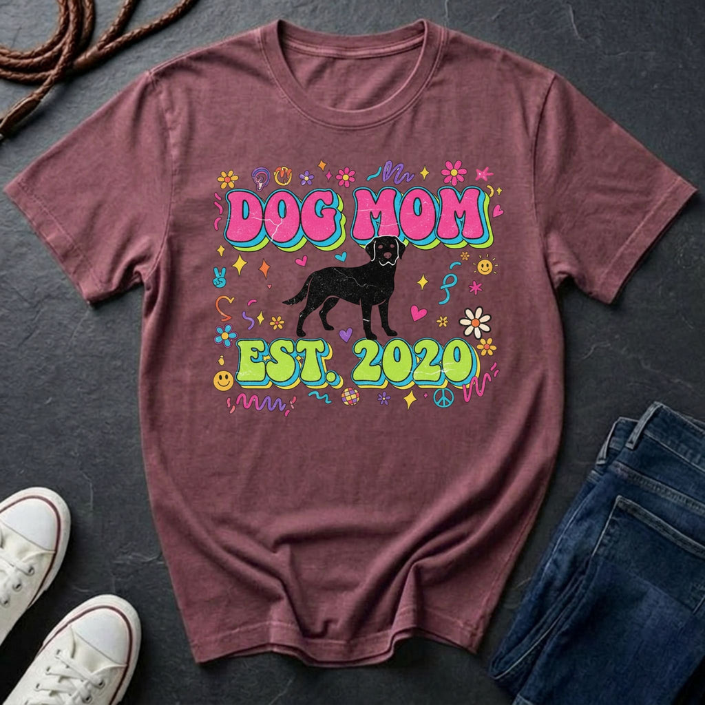 Maroon Comfort Colors t-shirt with 'Dog Mom Est. 2020' design on a dark surface with sneakers and jeans.