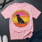 Pink Comfort Colors t-shirt with Golden Retriever design on a dark surface