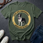 Green Comfort Colors t-shirt with a dog graphic and text on a dark surface with shoes and jeans.