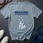 Gray Comfort Colors t-shirt with a dog graphic and text on a dark surface with shoes and jeans.