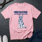 Pink Comfort Colors t-shirt with a dog graphic and text on a dark surface