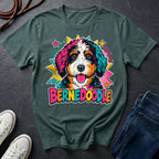 A bay short-sleeve comfort colors Tee featuring a colorful pop-art Bernedoodle dog graphic with the word 'BERNEDOODLE' in bright multicolor letters.