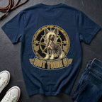 A navy blue graphic t-shirt laid flat on a dark slate background, styled with a pair of blue jeans, white sneakers, and a coiled rope. The back of the shirt features a large circular graphic of a Chinese Crested dog inside a compass design with the text 'GOT YOUR 6' below it.